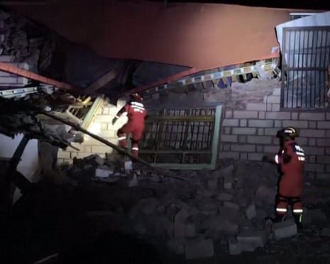 Rescuers use a torch while searching through building ruins in Nagqu city after the 7.0-magnitude quake in the northern Tibet region of China on Thursday night