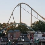 A tall rollercoaster track over an amusement park.
