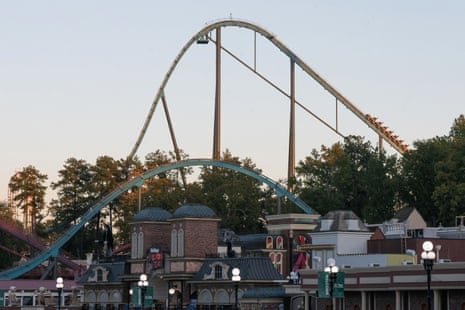 A tall rollercoaster track over an amusement park.