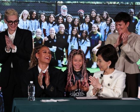 Trinity Rodman claps at her contract signing.