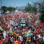 A huge crowd waving flags surrounds Lula's vehicle at a Copacabana campaign rally.